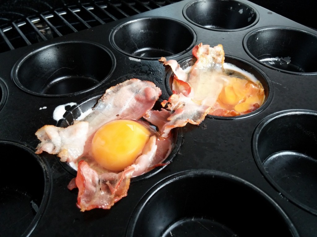 Nachdem der Schinken angegrillt wurde, wird ein Ei pro Form hineingegeben.