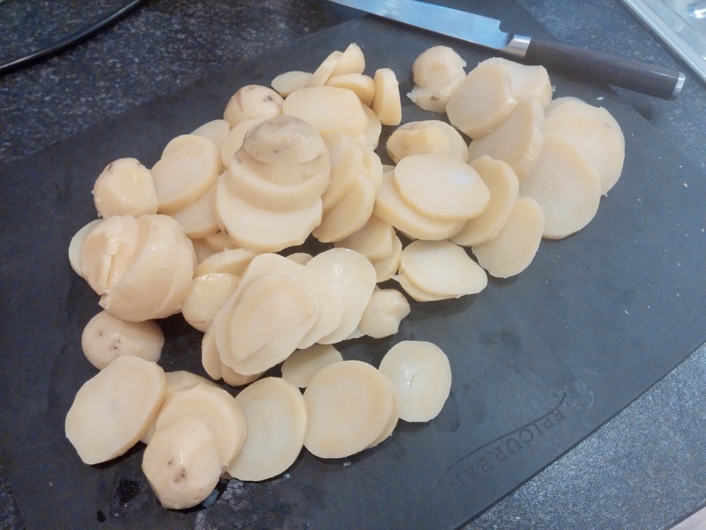 Die vorgekochten Pellkartoffeln werden in Scheiben geschnitten.