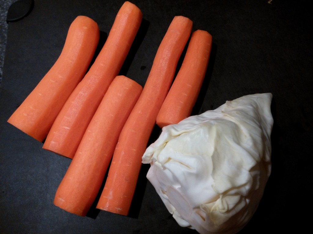 Geschälte Karotten liegen zum Marinieren bereit, der Spitzkohl muss noch fein geschnitten werden.