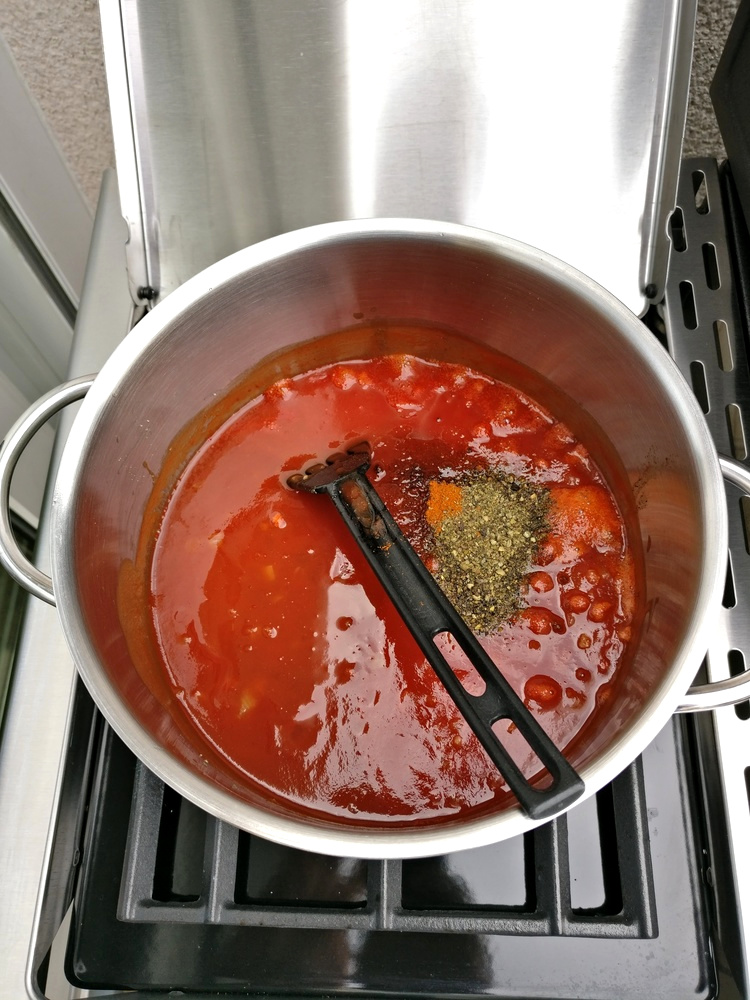 Passierte Tomaten, Worcester-Sauce, Apfel-Essig und Apfelsaft sowie Gewürze zugeben